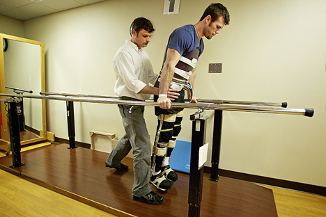 JEROME A. POLLOS/Press Mike Vredenburg works with Jake Allstot, a physical therapist assistant, in using legs braces and supports to gain mobility Monday at St. Luke's Rehabilitation Center in Spokane.
