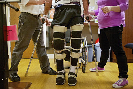 JEROME A. POLLOS/PressUsing leg braces and forearm crutches, Mike Vredenburg works on his upright mobility less than a month after he suffered a spinal cord injury in a snowmobile accident. "I haven't seen a patient progress as fast as him in 10 years," said Jake Allstot, a physical therapist assistant.